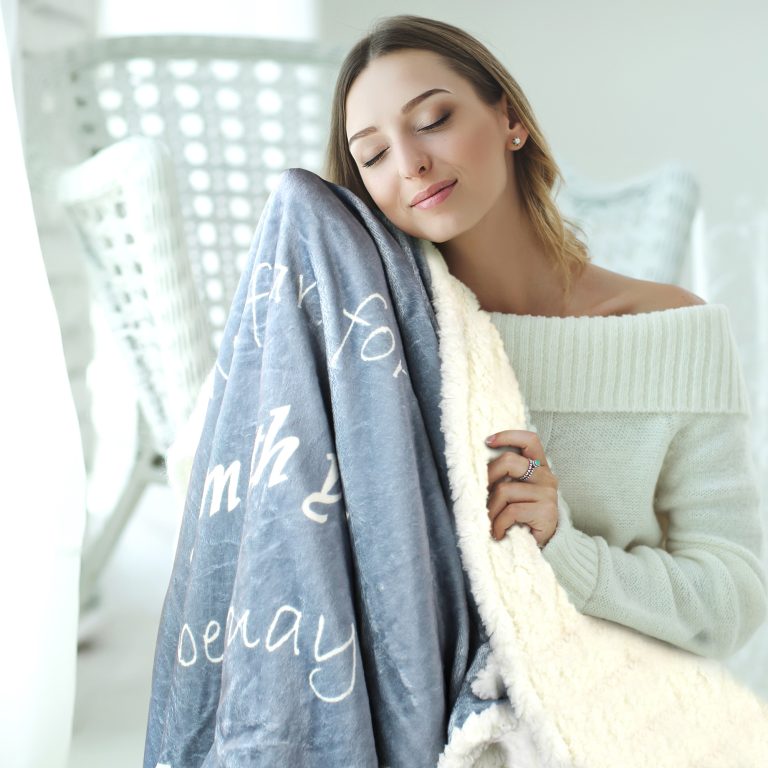 Woman hugging the sherpa side of a double layer prayer blanket